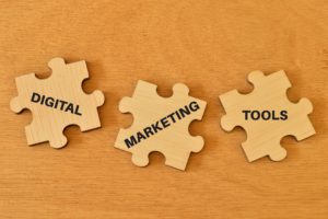 Wooden jigsaw puzzle with text DIGITAL MARKETING TOOLS.
